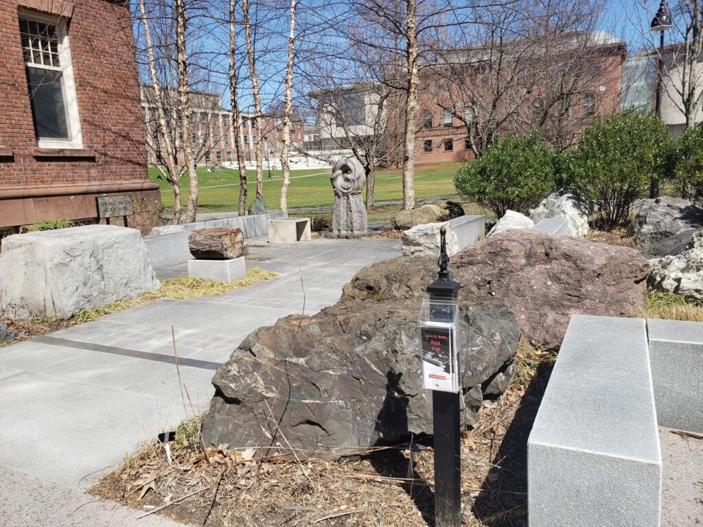 Outside of Smith College's science building, several large rocks with paved spaces for a crowd as well as sitting spaces, for outdoors geology and science classes.
